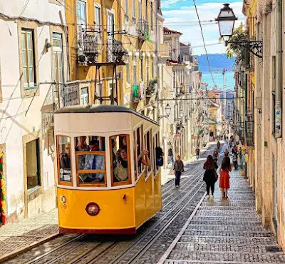 A classic yellow tram on a historic street in Lisbon, Portugal, an affordable European city.